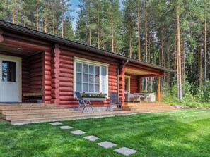 A log cabin with a porch, outdoor seating, and a well-maintained lawn. - Piilopirtti by Interhome (Liperi)