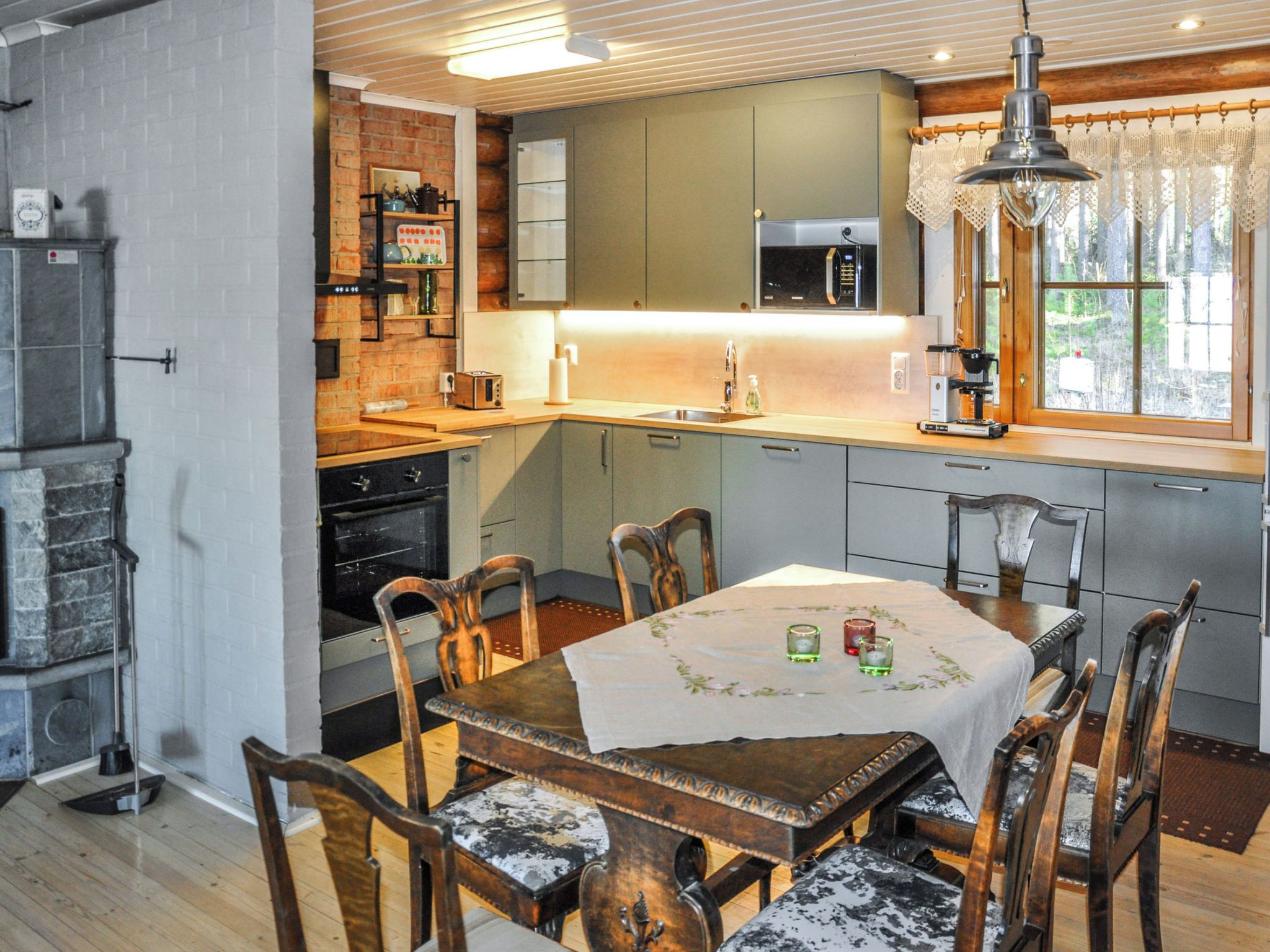Una cocina con una mesa de madera, sillas y una ventana.