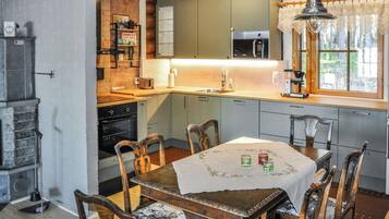 A kitchen with a wooden table, chairs, and a window.