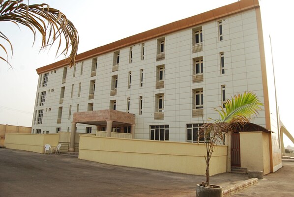A multi-story building with a flat roof, rectangular windows, and a central entrance with steps. - Royal Choice Inn (Abuja)