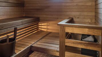 Una sala de sauna con bancos de madera, un ventanal pequeño y suelo de baldosas.