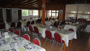 A large hall with multiple tables set for dining, arranged in rows. - Hisarlik Hotel (Çanakkale)