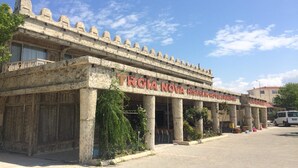 A historic building with a stone facade, columns, and a sign reading "TRIQA NOVA HISARLIK HOTEL & PANSIYON". - Hisarlik Hotel (Çanakkale)