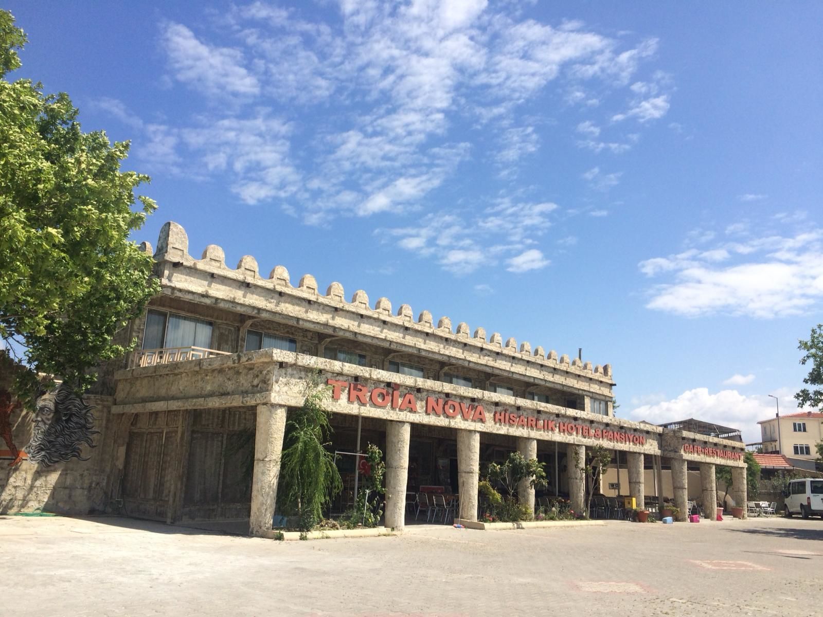 Un bâtiment historique doté d’une façade en pierre, de colonnes et d’un toit plat.