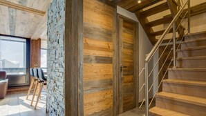 Un intérieur moderne avec un mur en pierre, des portes en bois et un escalier.