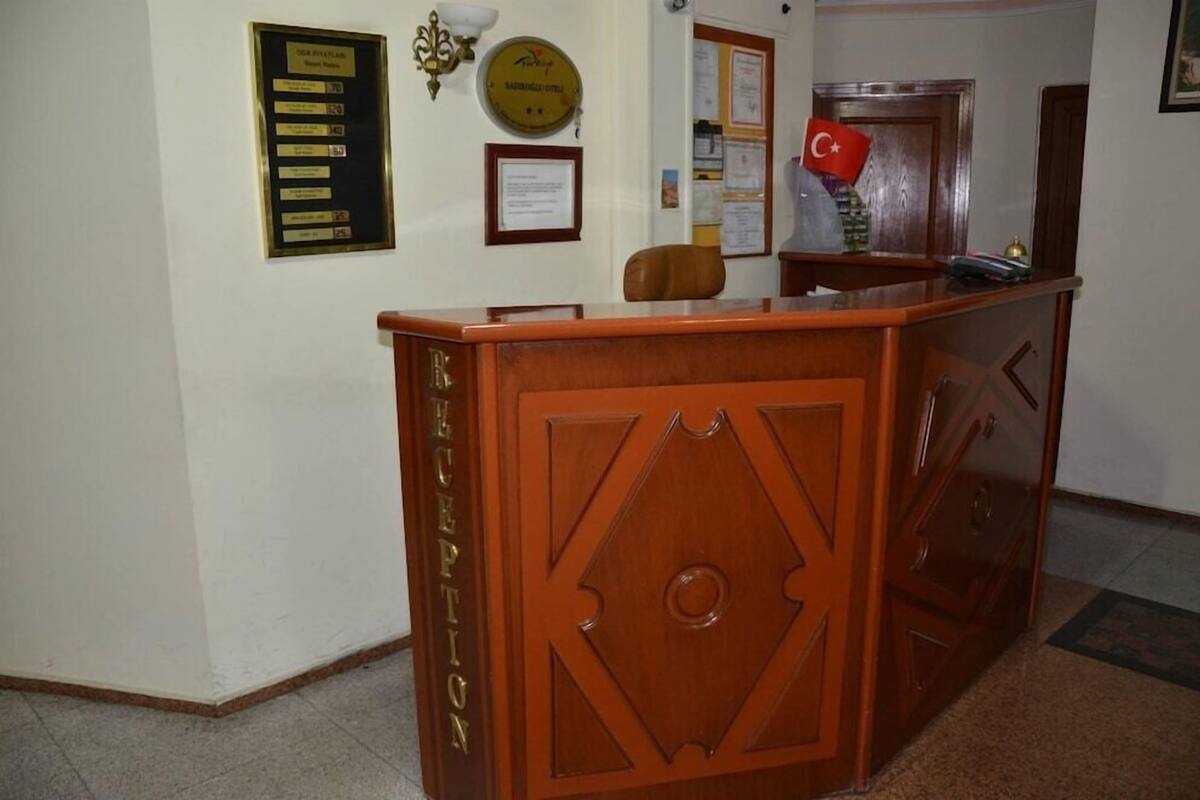 A reception desk with a wooden finish, a plaque on the wall, and a framed certificate.