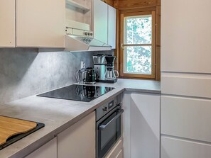 Una cocina moderna con estufa integrada, cafetera y horno.
