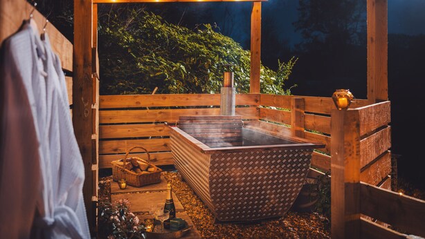 A wooden sauna with a hot tub, surrounded by wooden benches and a wooden deck. - The Hideaway & Spa Terrace at Tregoose Old Mill (Newquay)