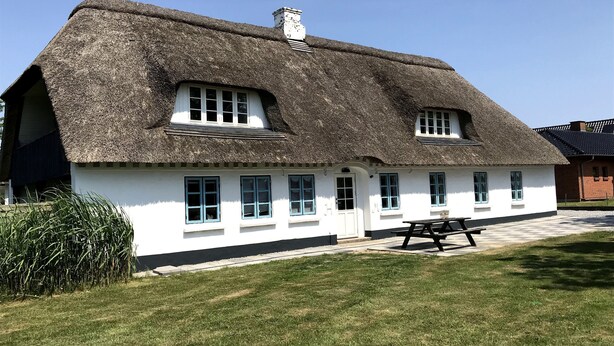 A thatched-roof house with white walls and multiple windows. - Nice holiday home near the beach (Rødekro)