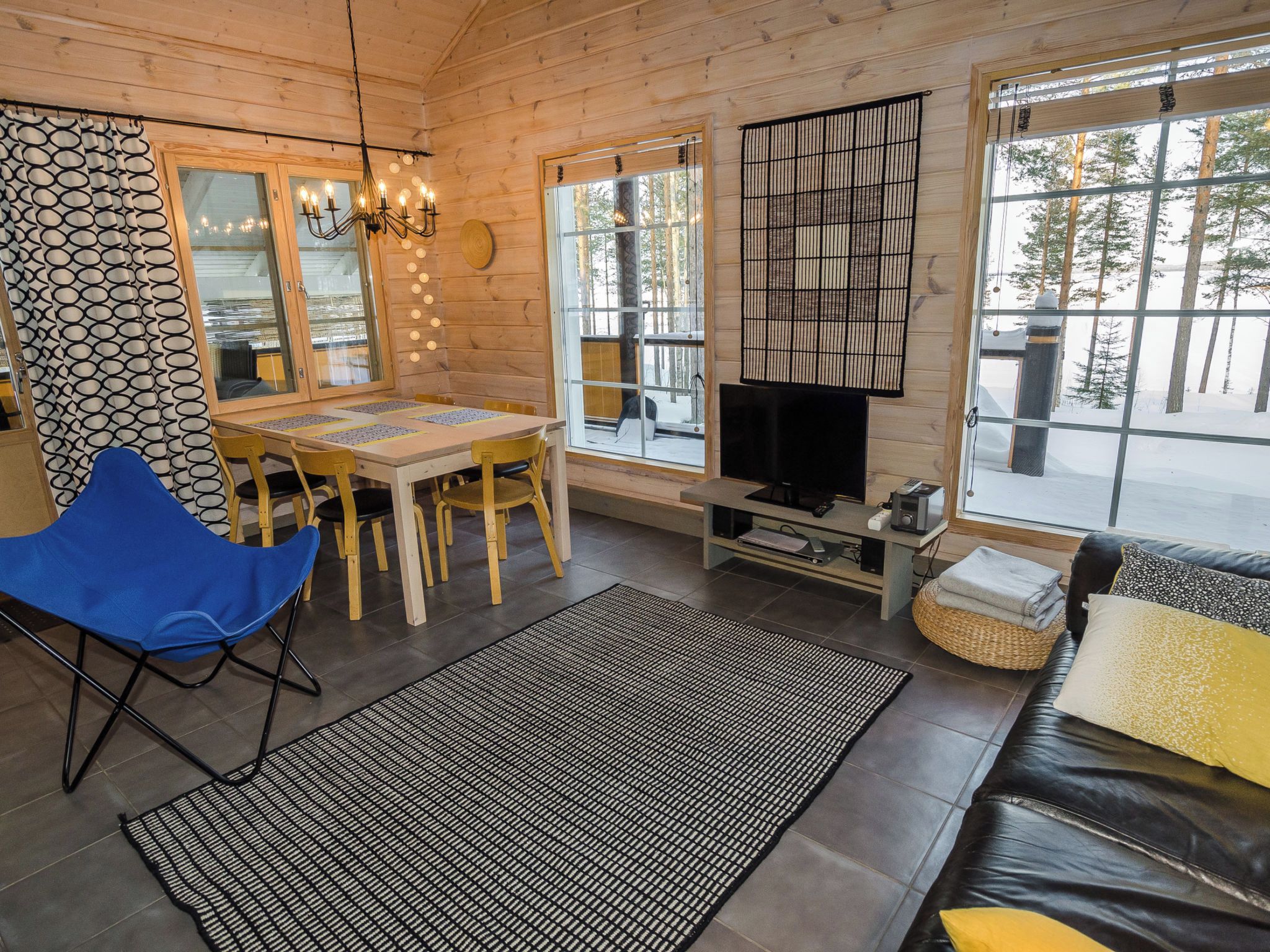 L'intérieur d'un chalet confortable, avec une table à manger, des chaises, un canapé et un téléviseur.