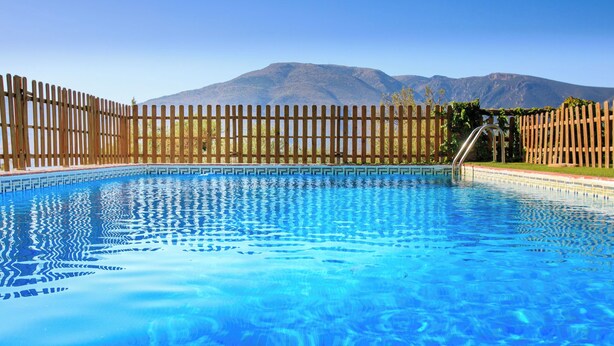 A swimming pool with a wooden fence and mountains in the background. - El Cerrillo - Cerro Negro by Interhome (Orgiva)