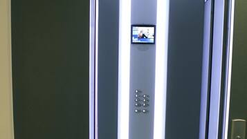 A modern elevator with a digital display and metallic interior.