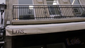 A building with a storefront labeled "Lois" and a balcony with a wrought iron railing. - Hotel Lois (A Coruña)
