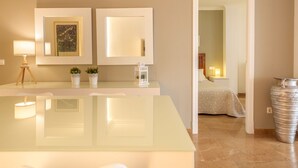 A modern bathroom with a glass vanity, two wall-mounted mirrors, a framed artwork, and a potted plant. - Maritimo by Interhome (Port d'Alcúdia)