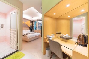 A modern hotel room with a bed, a desk with toiletries, and a shower area. - Story Inn City (Hualien City)