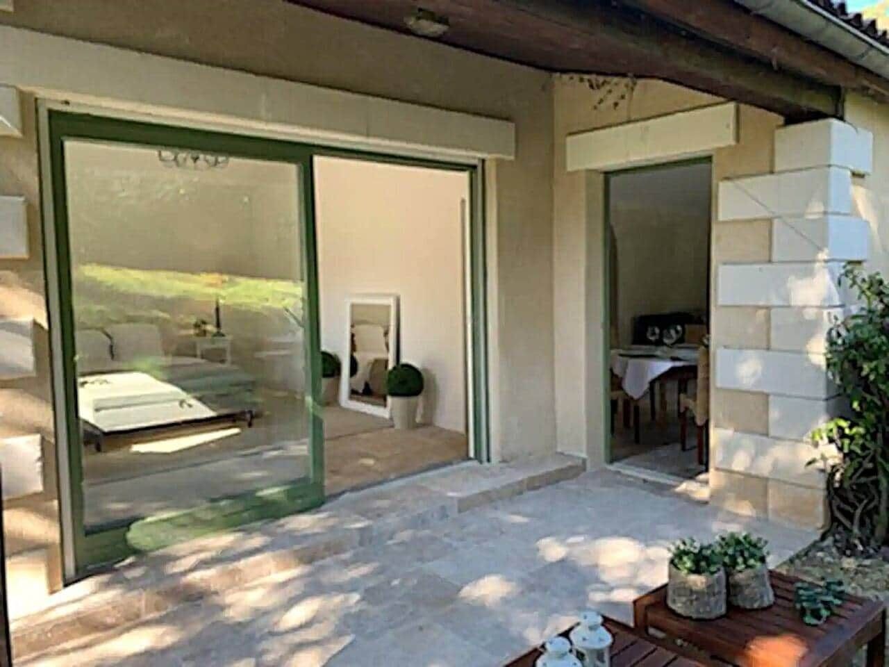 Una casa moderna con una puerta de vidrio que da a un patio.