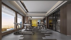 Et moderne fitnesscenter med løbebånd, crosstrainere og styrkeudstyr.