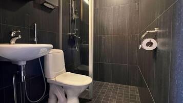 A modern bathroom with a white sink, toilet, and shower.