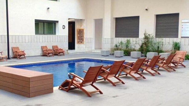 Un espace piscine avec des chaises longues et une petite piscine.
