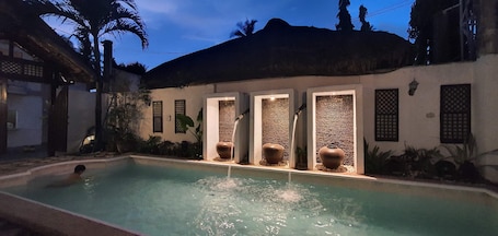 Una piscina al aire libre, sillones reclinables de piscina