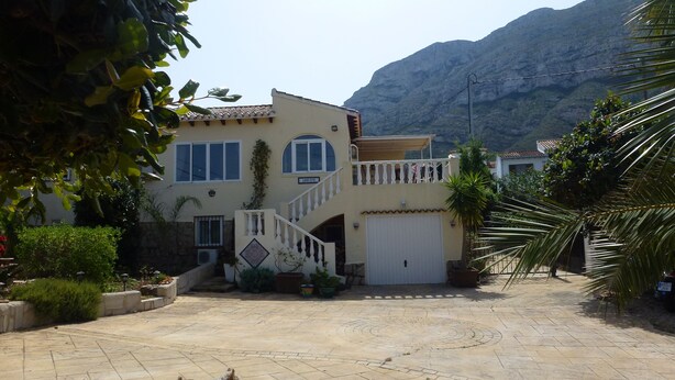 A two-story house with a balcony, a garage, and a paved driveway. - villa ground floor apartment (Dénia)