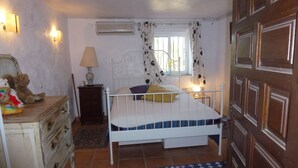 A bedroom with a bed, dresser, lamp, and a window with curtains. - villa ground floor apartment (Dénia)