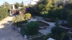 A garden with a stone pathway, various plants, and a small water feature. - villa ground floor apartment (Dénia)