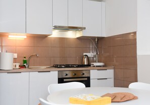 Comfort appartement, op benedenverdieping | Privékeuken | Een koelkast met diepvriezer, een microgolfoven, een oven, een kookplaat