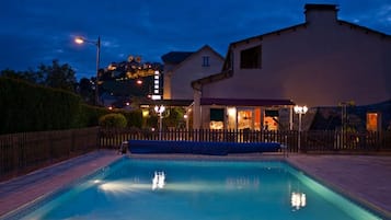 Una piscina al aire libre de temporada, sillones reclinables de piscina