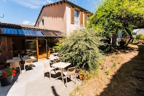 A patio area with outdoor seating and a covered entrance. - Les Messageries (Saint-Flour)