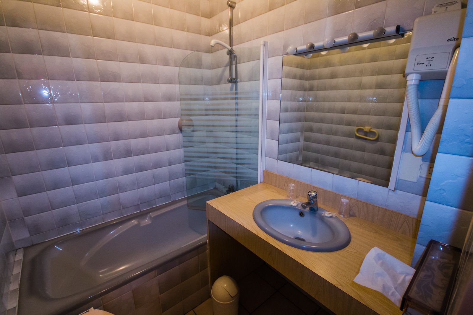 A bathroom with a bathtub, a sink, and a mirror.