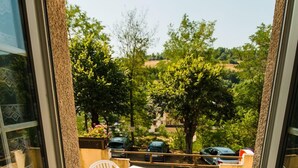 A view from a room with a sliding glass door to an outdoor patio area. - Les Messageries (Saint-Flour)