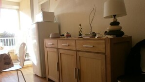 Eine Küche mit Holzausstattung, einem Kühlschrank, einem Essbereich mit Stuhl und Tisch.
