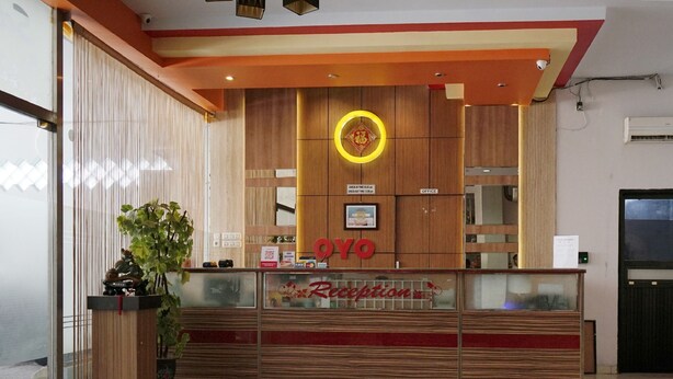 A reception desk with a wooden finish, a circular logo above it, and a sign that reads "Reception".