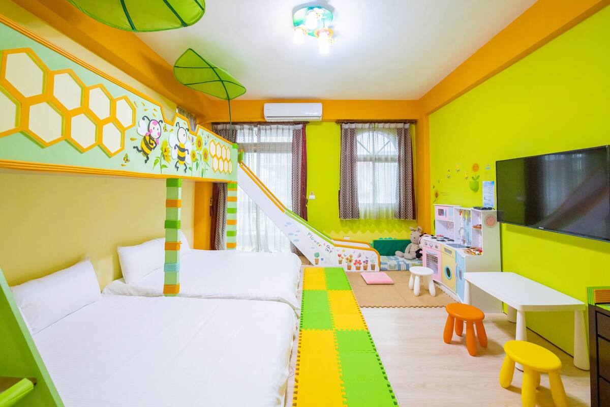 A brightly colored children's room with a bed, play area, and a TV.