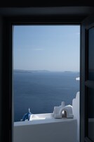 A view from a window overlooking a body of water with distant landforms.
