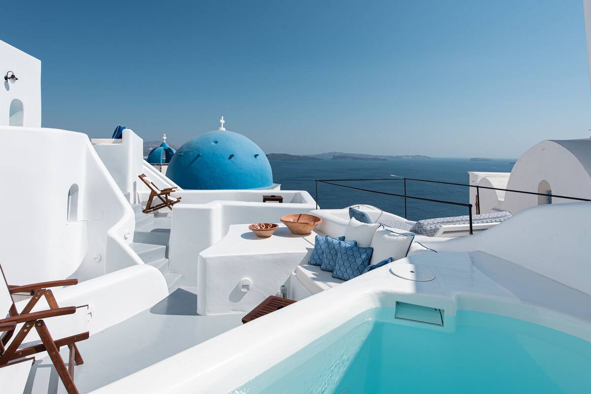 Ein weißes Gebäude mit einer blauen Kuppel und einem Pool.