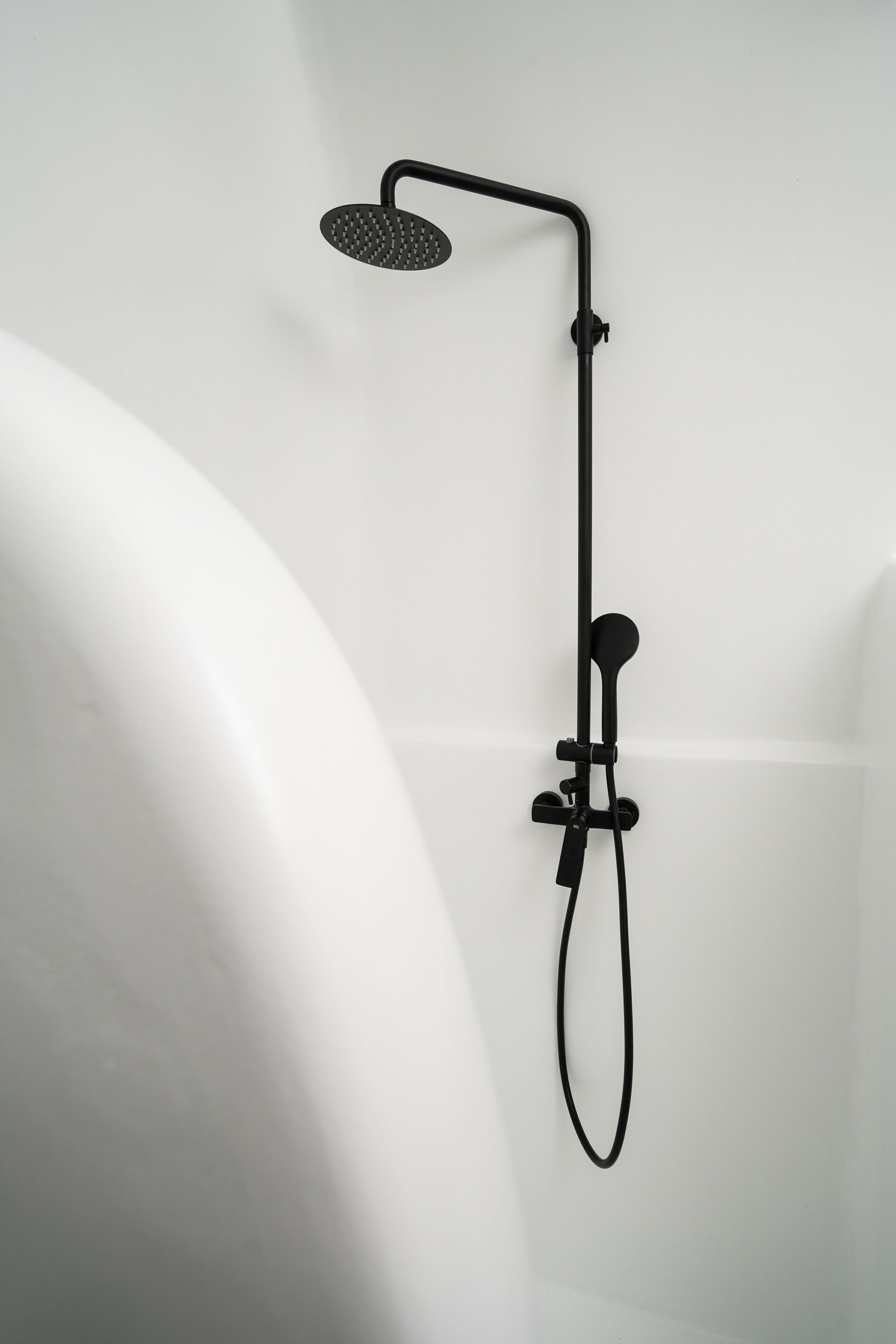 A modern shower with a handheld showerhead and a handheld hose.