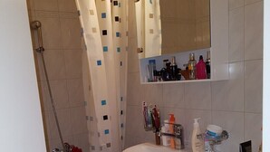 Une salle de bain avec une douche, un lavabo et des toilettes.