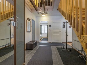 A hallway with a staircase, a bench, a door, and a mirror. - Vanamotupa by Interhome (Äkäslompolo)