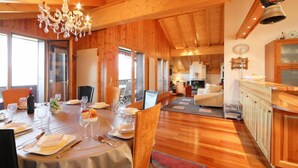 A wooden cabin interior with a dining area, kitchen, and living space. - Sunset B 11 by Interhome (Villars)