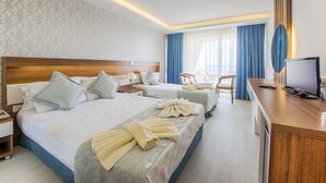 Una habitación de hotel con dos camas, un escritorio, televisor y baño.