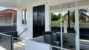 A modern building with a black door, a glass entrance, and a metal railing. - D-Tas appartement en studio (Paramaribo)