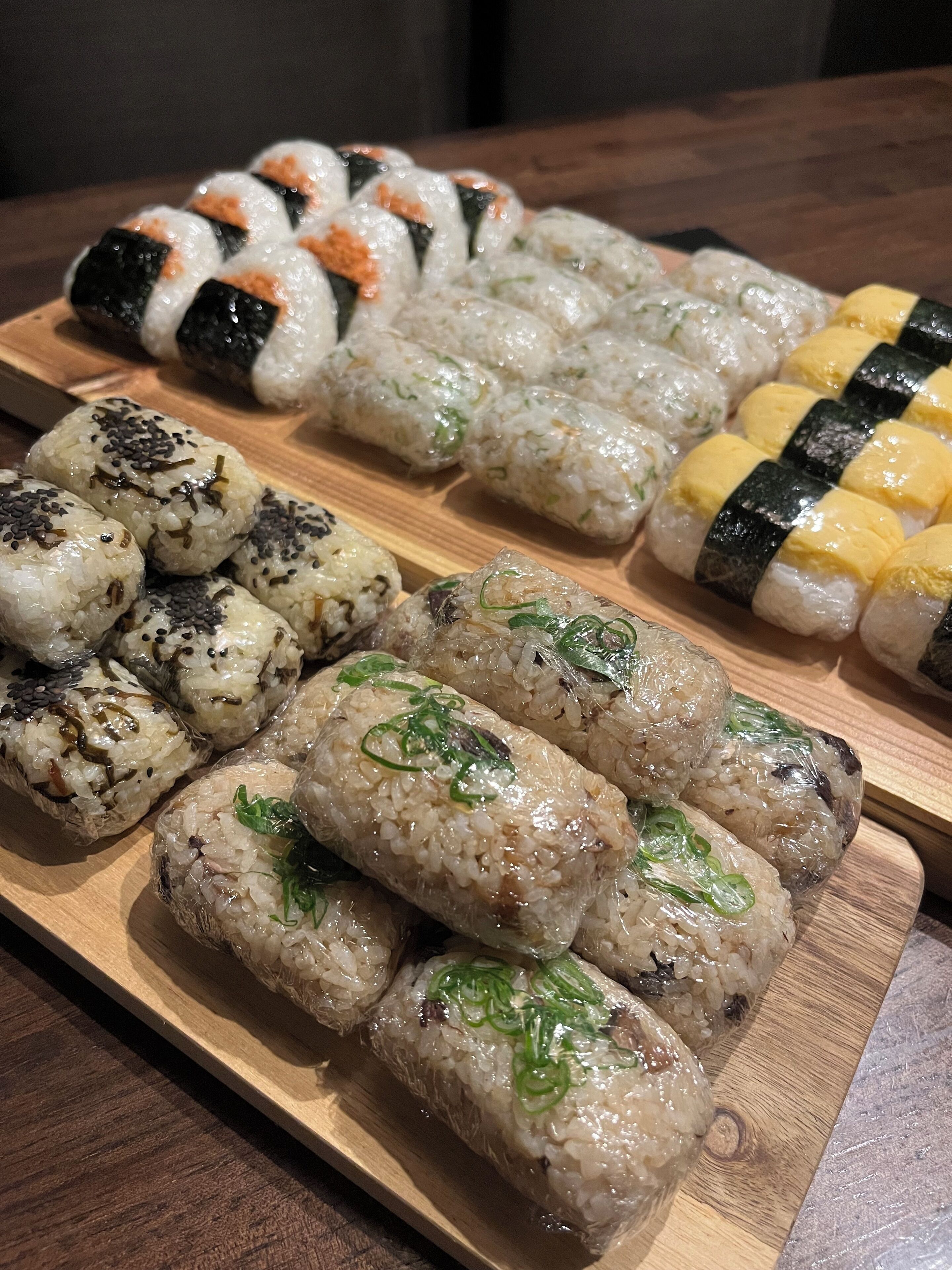 Une planche en bois sur laquelle sont disposés différents types de sushis et de plats à base de riz.