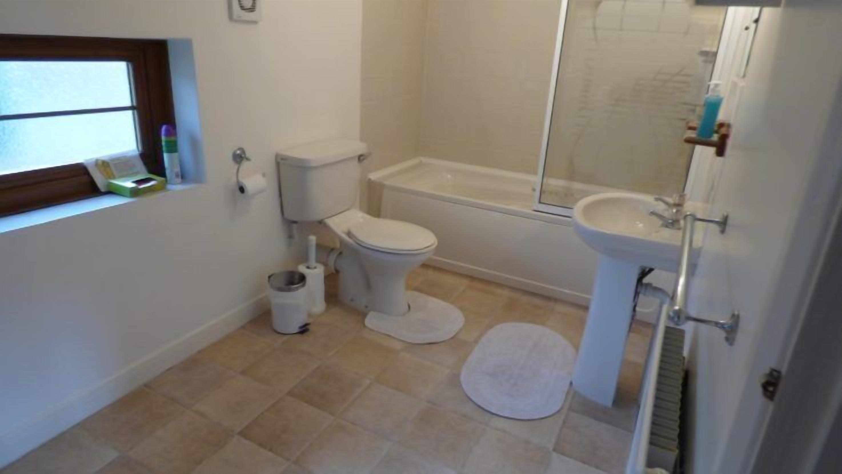 A bathroom with a toilet, bidet, bathtub, and sink.