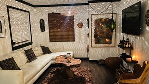 Un salon moderne avec un canapé blanc, une table basse en bois et un tapis à motifs.