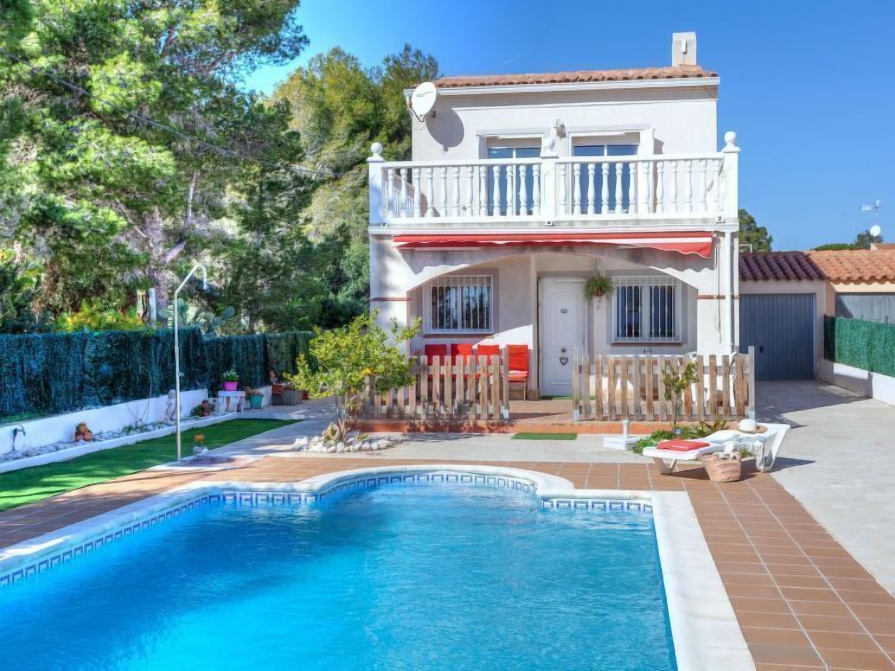 A two-story house with a swimming pool, a fenced patio, and a garden.
