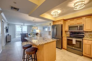 A modern kitchen with granite countertops, stainless steel appliances, and wooden cabinets.