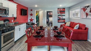 Eine moderne Küche mit Essbereich, roter und weißer Einrichtung und einem roten Sofa.