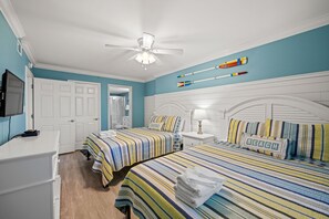 A bedroom with two beds, a ceiling fan, and a wall-mounted TV. - Beautifully remodeled, oceanfront condo + Free Attraction Tickets! (North Myrtle Beach)